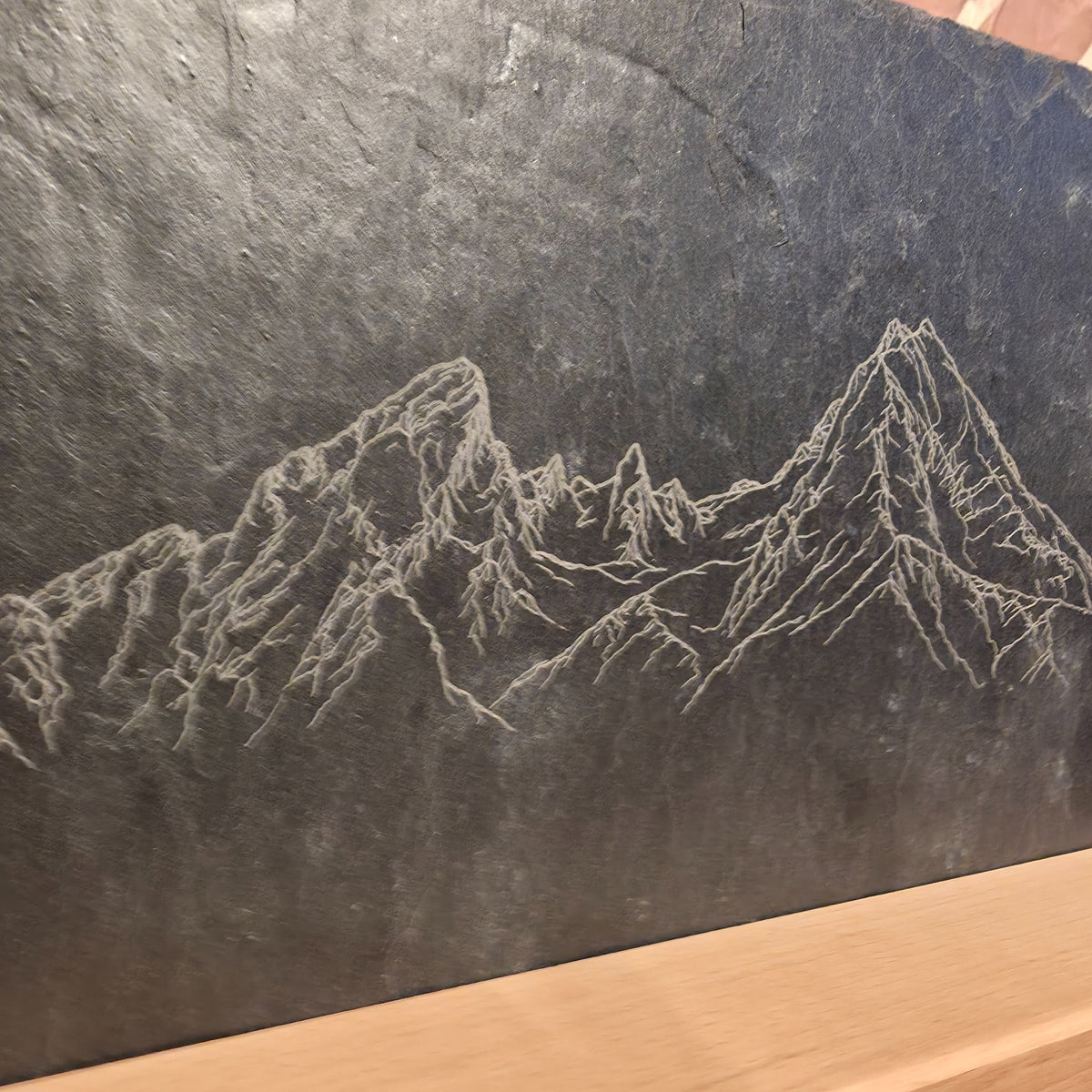 Nahaufnahme der feinen Watzmann-Berggravur auf der natürlich strukturierten dunkelgrauen Schieferoberfläche.